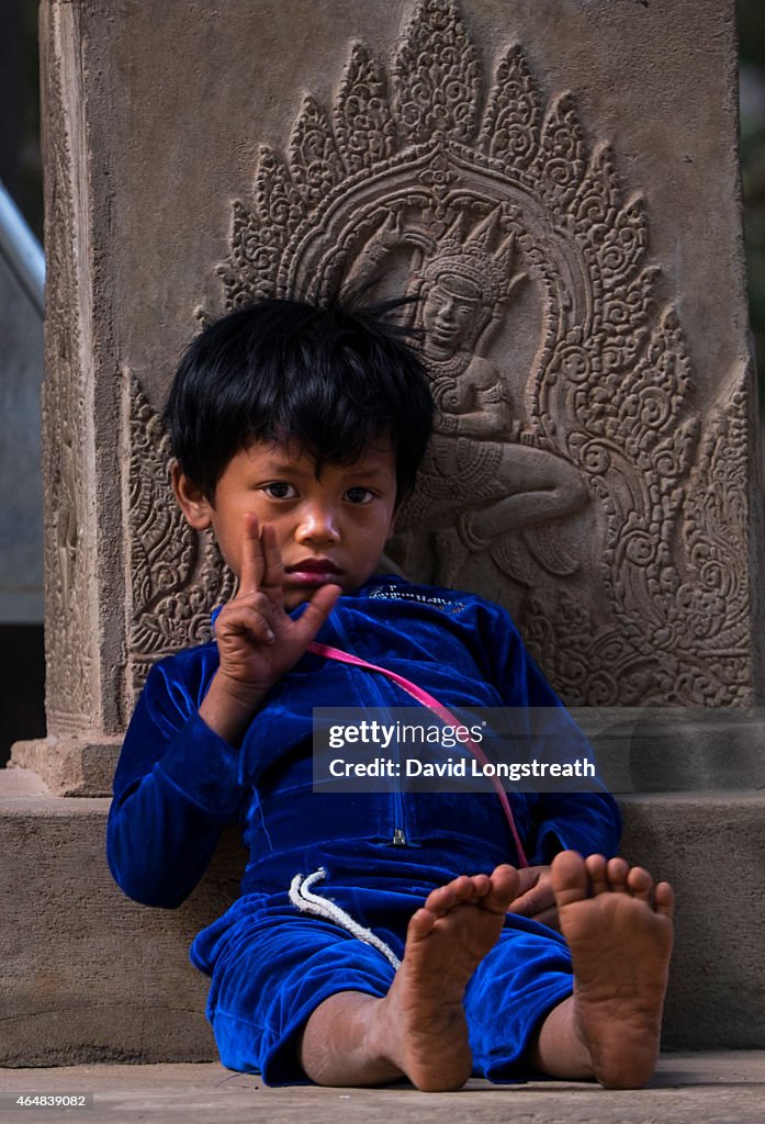 A Cambodian boys watches tourist outside the complex of...