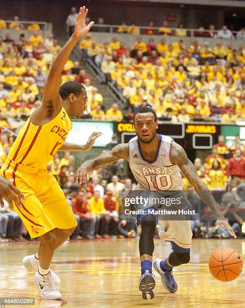 Guard Naadir Tharpe of the Kansas Jayhawks brings the ball down the court during the first half in front of Monte Morris of the Iowa State Cyclones...