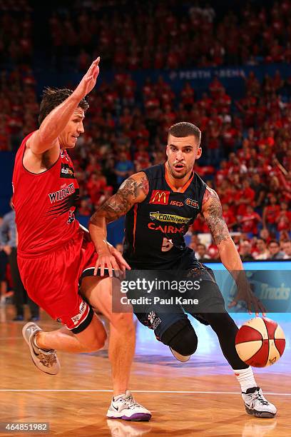 Scottie Wilbekin of the Taipans drives to the basket against Damian Martin of the Wildcats during game two of the NBL Finals series between the Perth...