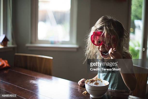 girl eating cereal with goggles on - safety glasses at home stock pictures, royalty-free photos & images