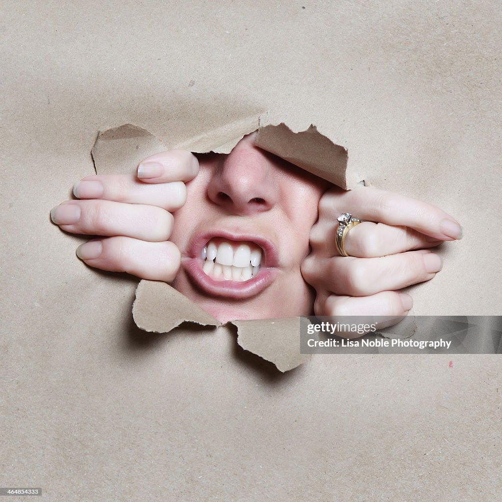 Mouth Nose and Hands Breaking through Brown Paper