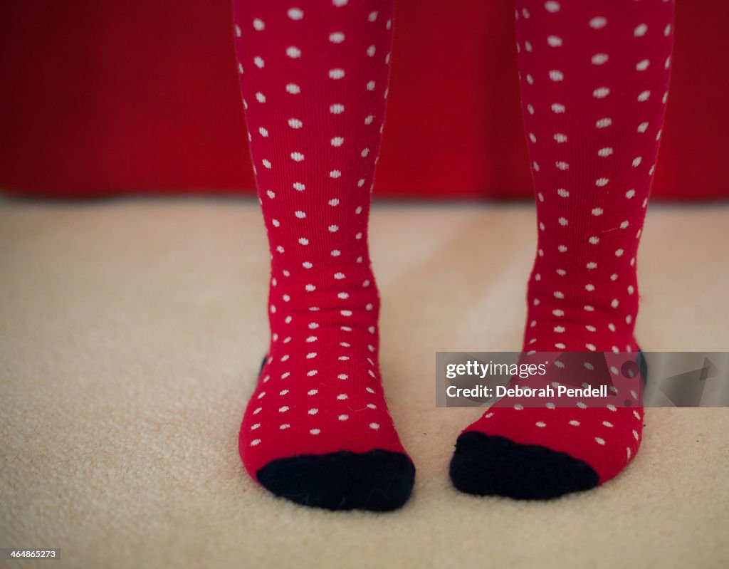 Pair of feet wearing red spotty socks