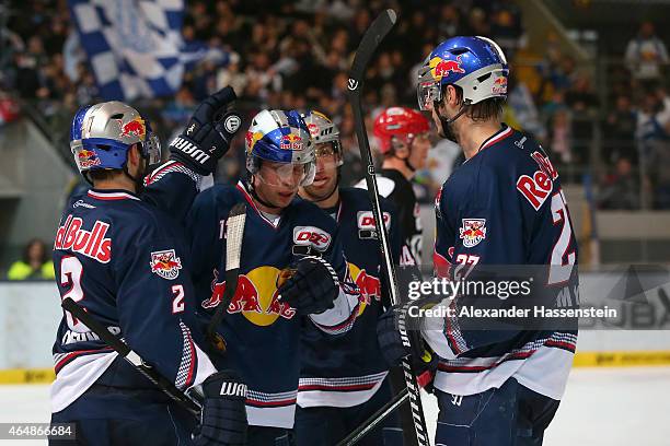 Michael Wolf of Muenchen celebrates scoring the 4th team goal with his team mates during the DEL Ice Hockey match between EHC Red Bull Muenchen and...