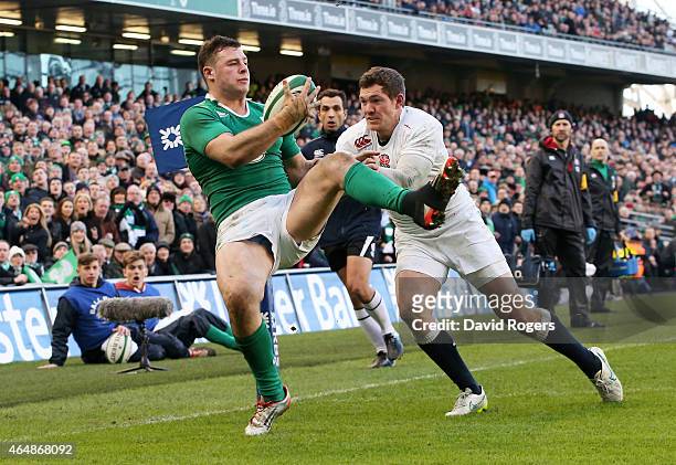 Robbie Henshaw of Ireland takes a high ball to score the opening try despite the efforts of Alex Goode of England during the RBS Six Nations match...