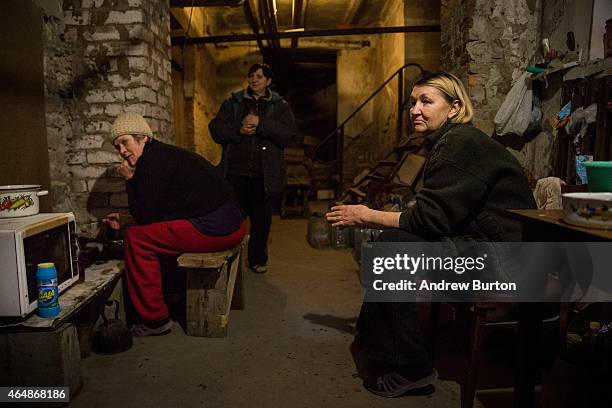 Women prepare a lunch of oat pancakes in the basement of the Petrovskiy neighborhood cultural center, where they live, on March 1, 2015 in Donetsk,...