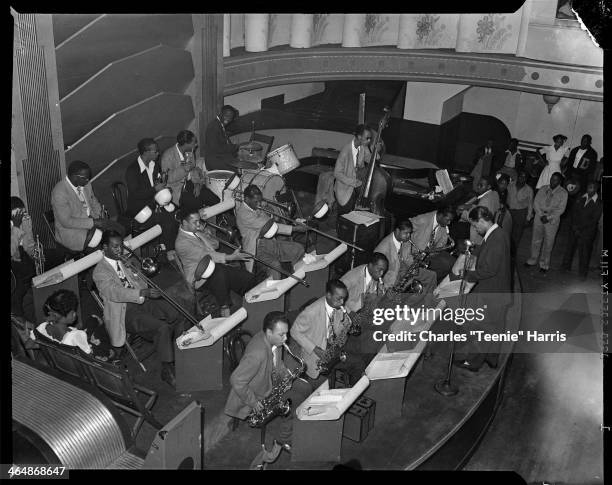 Billy Eckstine conducting his orchestra with Charlie Parker on saxophone third from left, Dizzy Gillespie, Art Blakey on drums, Sarah Vaughan seated...