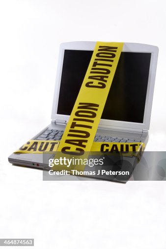 A Computer Wrapped Laptop Computer Wrapped In Yellow Caution Tape High-Res Stock Photo ...