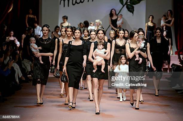 Models walk the runway with babies and children at the Dolce & Gabbana Autumn Winter 2015 fashion show during Milan Fashion Week on March 1, 2015 in...