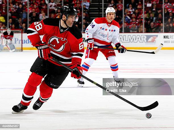 Jaromir Jagr of the New Jersey Devils takes the puck as Aaron Volpatti of the Washington Capitals defends at Prudential Center on January 24, 2014 in...