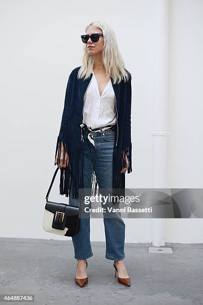 Courtney Trop poses wearing a Sandro jacket and Saint Laurent bag on March 1, 2015 in Milan, Italy.