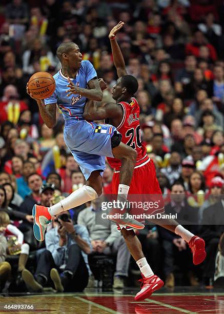 Jamal Crawford of the Los Angeles Clippers leaps to pass over Tony Snell of the Chicago Bulls at the United Center on March 1, 2015 in Chicago,...