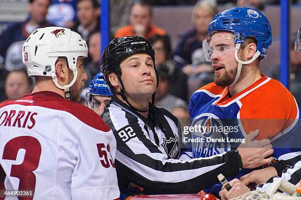 Jesse Joensuu of the Edmonton Oilers exchanges words after the whistle with Derek Morris of the Phoenix Coyotes during an NHL game at Rexall Place on...