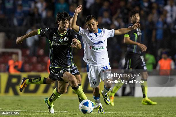 Christian Bermudez of Queretaro fights for the ball with Jonathan Lacerda of Santos during a match between Queretaro and Pumas UNAM as part of the...