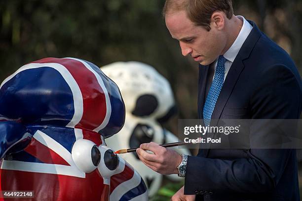 Prince William, Duke of Cambridge paints the eye of "shaun the sheep" at the British Ambassador's official residence on March 2, 2015 in Beijing,...