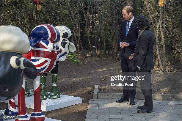 Prince William, Duke of Cambridge speaks with a chinese artist in front of "shaun the sheep" at the British Ambassador's official residence on March...