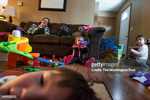 Amber McGeshick watches tv with her daughter, Aiyana Roque de Escobar, 16 mos., her niece Audrina Cornelius and nephew, Brayden Cornelius at her home...