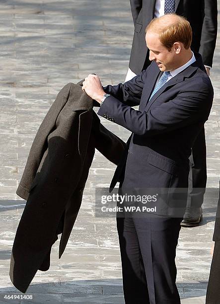 Prince William, Duke of Cambridge puts on a coat during a visit to the Forbidden City on March 2, 2015 in Beijing, China. The Duke of Cambridge is on...