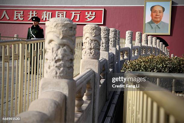 Chinese policeman guards in front of a giant portrait of the late chairman Mao Zedong on the Tiananmen Gate at Tiananmen Square on March 2, 2015 in...