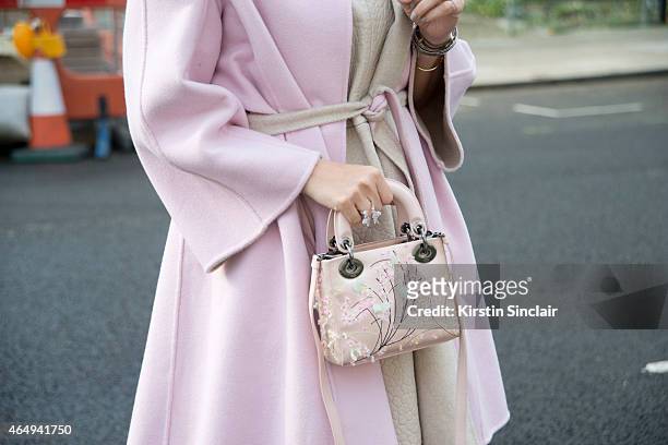 Fashion stylist Aram Kabbani wears a Max Mara coat, Dior bag and Topshop unique dress. On February 24, 2015 in London, England.