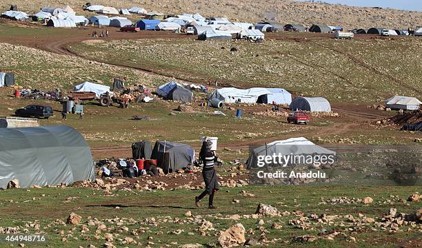 An Ezidi woman carries a bucket outskirts of Sinjar mountain, Mosul, on March 2, 2015. Ezidis fled from Daesh attacks shelter in Sinjar Mountain and...