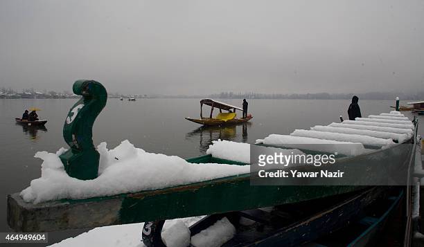Kashmir boatman rows his boat amid a fresh snowfall on March 2, 2015 in Srinagar, Indian Administered Kashmir, India. Several parts of the Kashmir...