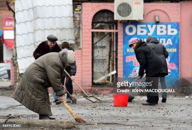 Residents sweep up debris near Lenin square in Debaltseve on March 2, 2015. The Ukrainian town of Debaltseve, which fell to pro-Russian separatists...