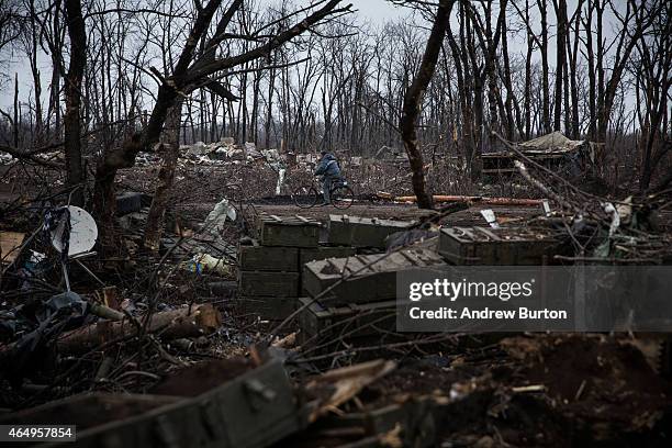 Man rides his bike through a desimated battlefield where the Ukrainian army was defeated by pro-Russian rebels on March 2, 2015 on the outskirts of...