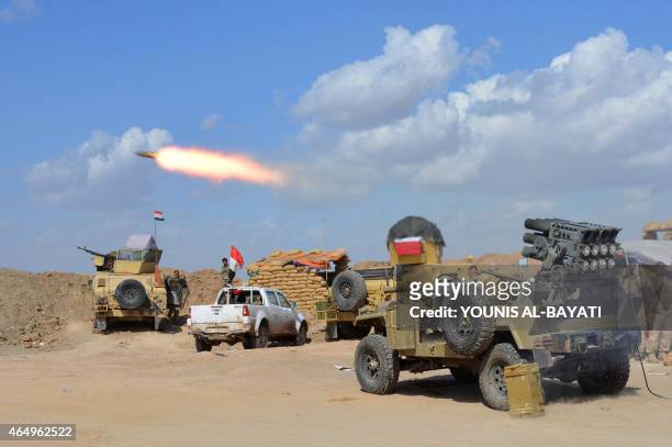 Iraqi government forces and allied militias fire weaponry from a position in the northern part of Diyala province, bordering Salaheddin province, as...