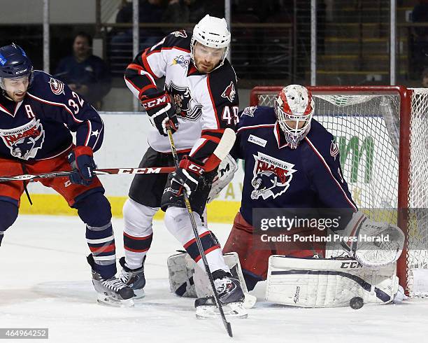 Alex Bolduc of Portland tries to slap the puck past Anton Forsberg of Springfield during the first period as Springfield's Frederic St. Denis defends.