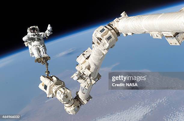 In this handout from National Aeronautics and Space Administration or NASA, Astronaut Stephen K. Robinson, STS-114 mission specialist, anchored to a...