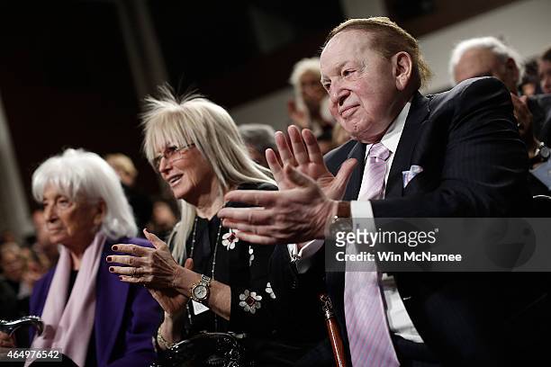 American businessman Sheldon Adelson applauds during a roundtable discussion on Capitol Hill with his wie Miriam Adelson and Marion Wiesel March 2,...