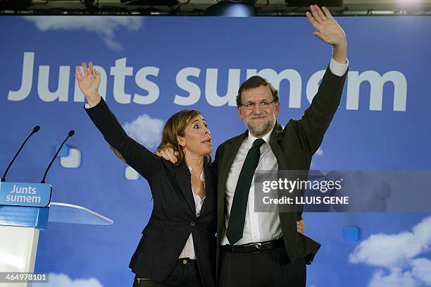 Spanish Prime Minister Mariano Rajoy and Popular Party's leader of the Catalonia region Alicia Sanchez Camacho wave to supporters during the closure...