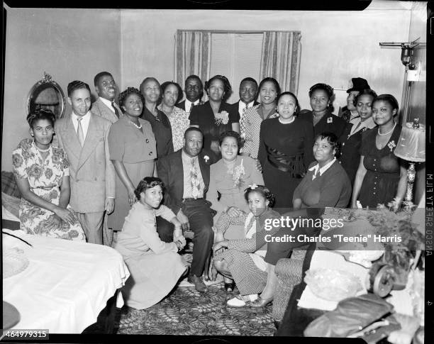 Group portrait of Mr and Mrs Gardner seated in center, with Mary Lee Gardner, Betty Jane Gardner wearing saddle shoes squatting beside them, and...