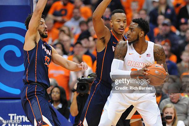 Rakeem Christmas of the Syracuse Orange controls the ball against the defense of Darion Atkins and Anthony Gill of the Virginia Cavaliers during the...