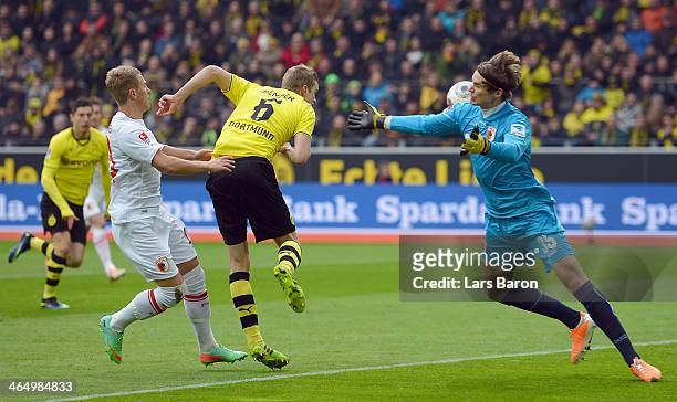 Sven Bender of Dortmund heads his teams first goal against Matthias Ostrzolek and goalkeeper Marwin Hitz of Augsburg during the Bundesliga match...