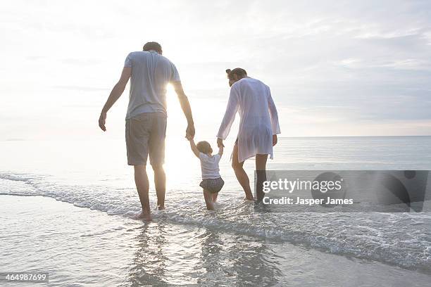 family walking in the sea in thailand - mum dad and baby fotografías e imágenes de stock