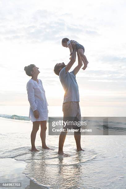 family playing at the beach in thailand - holding aloft stock pictures, royalty-free photos & images