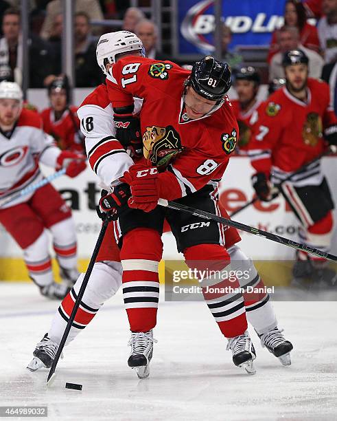 Marian Hossa of the Chicago Blackhawks is harrased by Jay McClement of the Carolina Hurricanes at the United Center on March 2, 2015 in Chicago,...