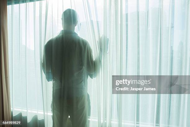 man looking out of a window - man silhouette stock pictures, royalty-free photos & images