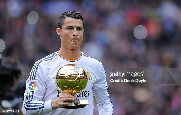 Cristiano Ronaldo of Real Madrid CF holds the Ballon d'Or 2013 award prior to he start of the La Liga match between Real Madrid CF and Granada CF at...