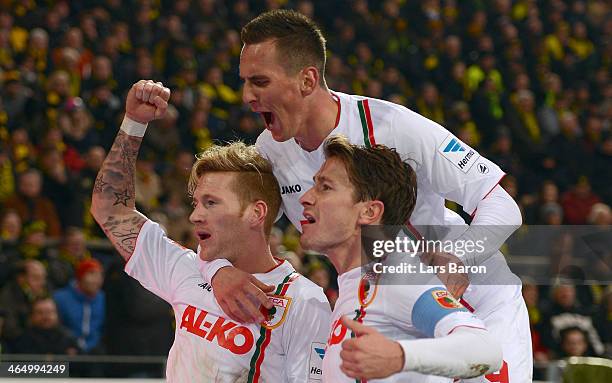 Andre Hahn of Augsburg celebrates with team mates after Sven Bender of Dortmund scored an own goal during the Bundesliga match between Borussia...