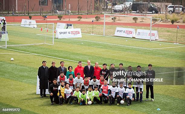 Britain's Prince William poses for a picture with students and officials during his visit to a Premier League football training camp in Shanghai on...