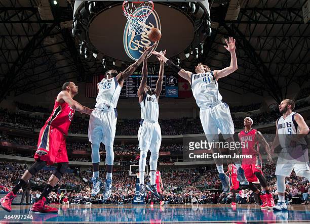Bernard James, Al-Farouq Aminu and Dirk Nowitzki of the Dallas Mavericks go up for a rebound during the game against the New Orleans Pelicans on...