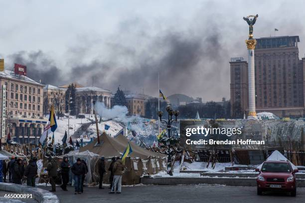 Smoke rises from clashes between anti-government protesters and police on Hrushevskoho Street near Dynamo stadium, as seen from Independence Square,...