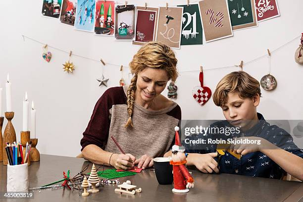 mother and son making x mas decorations - child craft stock pictures, royalty-free photos & images