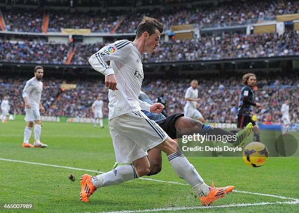 Gareth Bale of Real Madrid CF crosses the ball while being tackled by Brayan Angulo of Granada CF during the La Liga match between Real Madrid CF and...