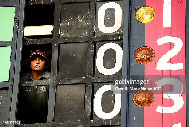 Scoreboard attendant watches on during the 2015 ICC Cricket World Cup match between South Africa and Ireland at Manuka Oval on March 3, 2015 in...