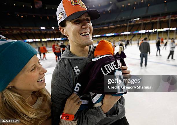 Ben Lovejoy holds his son with his wife during the family skate after the team practice for the 2014 Coors Light NHL Stadium Series against the Los...
