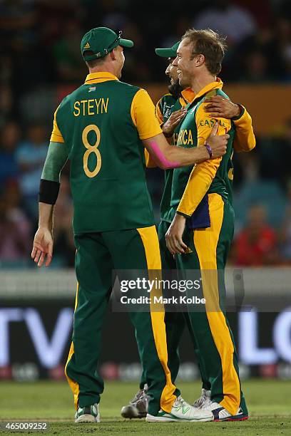 Dale Steyn and Imran Tahir of South Africa congratulate AB de Villiers of South Africa as he celebrates taking the wicket of John Mooney of Ireland...