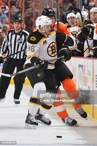 Kevan Miller of the Boston Bruins checks Jay Rosehill of the Philadelphia Flyers at the Wells Fargo Center on January 25, 2014 in Philadelphia,...